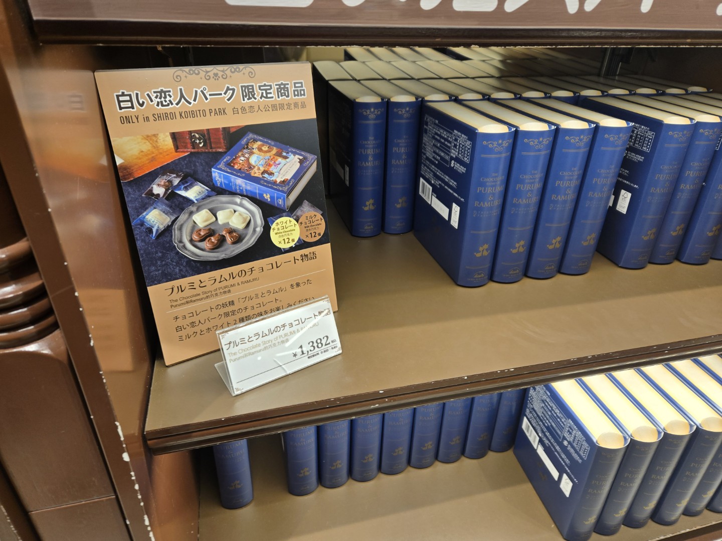 A photo of a book depicting a white snow fox with red cheeks and red-tipped ears. It looks like a Pikachu if it were drawn using only red and white ink!